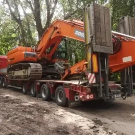 Transport maszyn rolniczych koparek na powrocie niskopodwozia z Europy